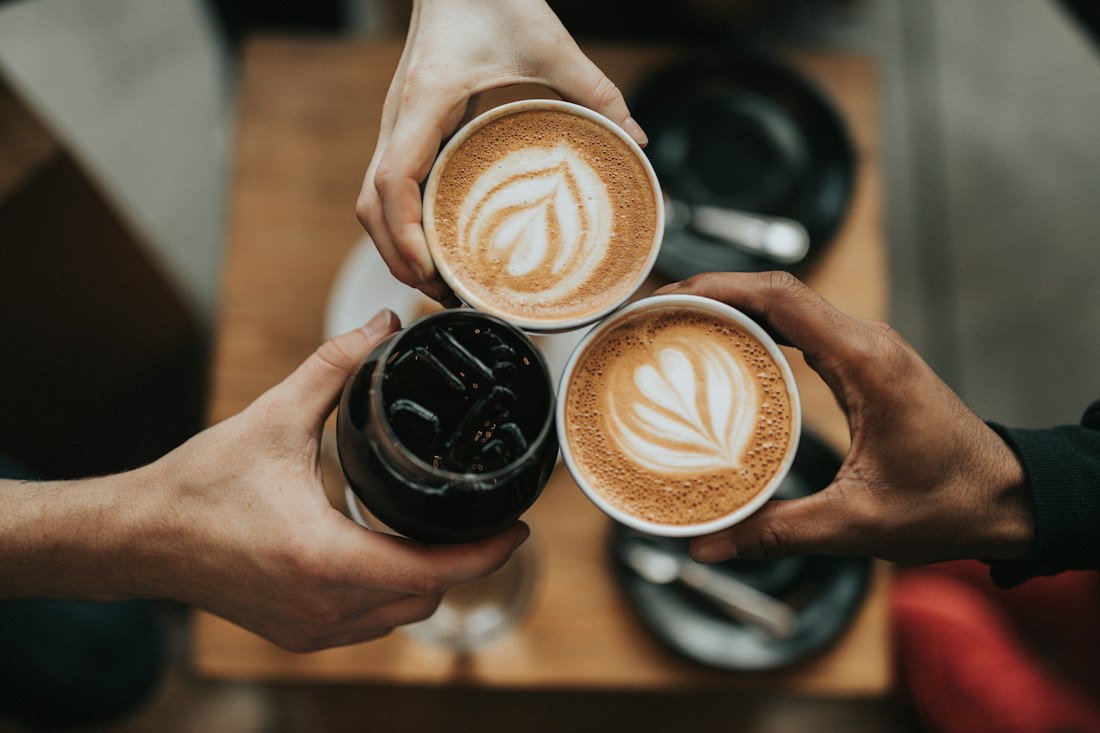 Guests clinking lattes with latte-art hearts