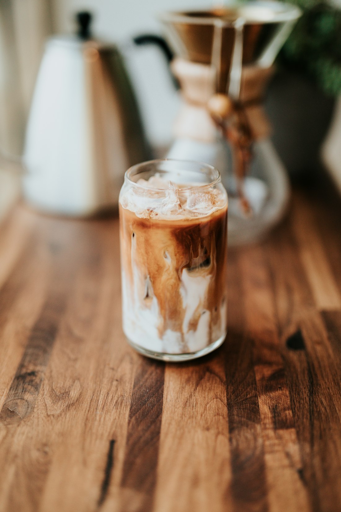 Iced latte with cream swirling into coffee